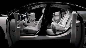 Automóvil con las cuatro puertas abiertas, exhibiendo el interior. Los asientos, el volante y el tablero son de color blanco y negro