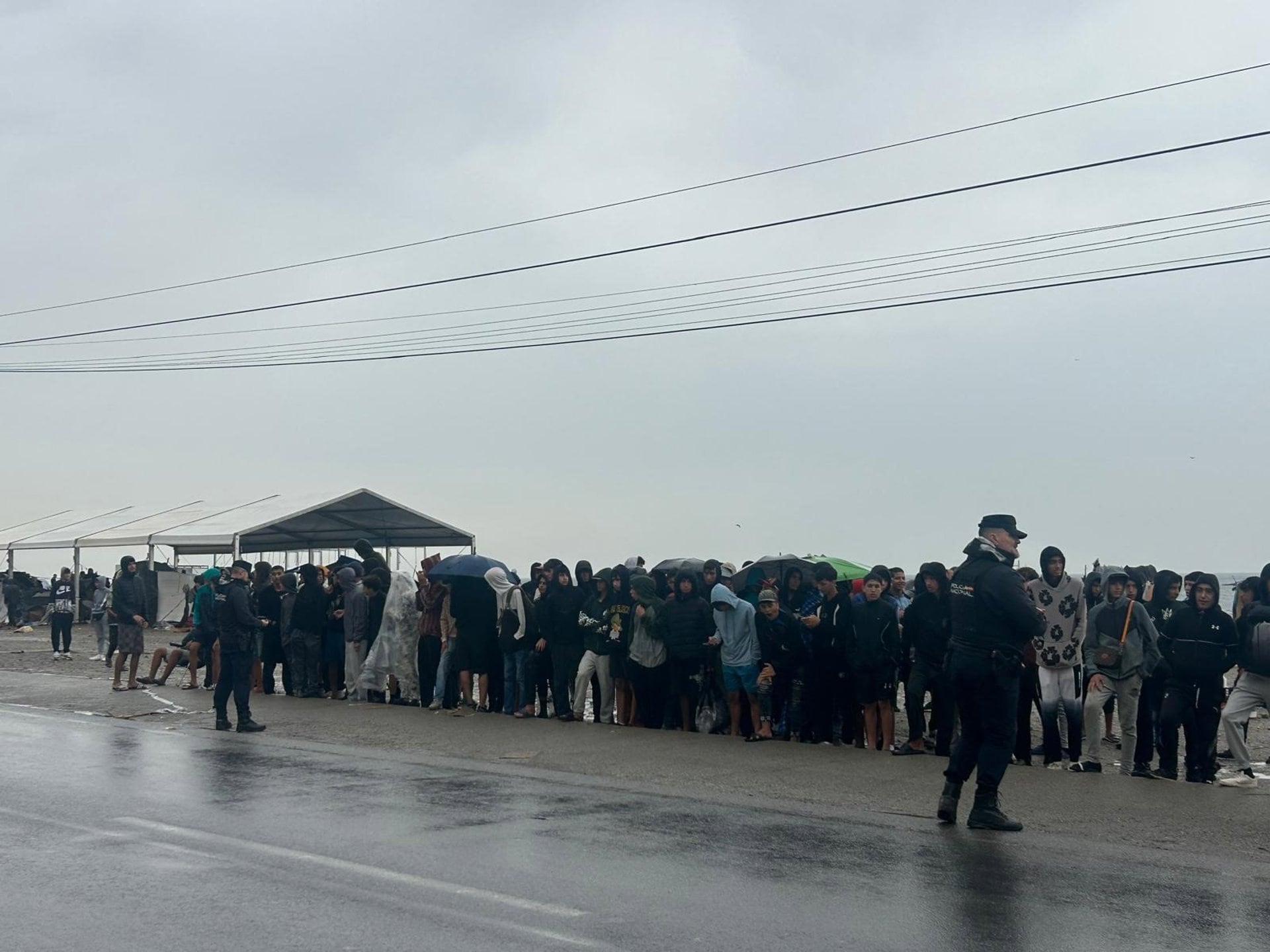 06/10/2026 Más de 50 menores inmigrantes solos esperan bajo la lluvia en el Guano (Ceuta) su traslado a un centro de acogida. CEUTA, 6 (EUROPA PRESS) Un grupo de más de 50 menores migrantes solos se han colocado desde la mañana de este martes en fila junto a la carretera en la zona del Guano de Ceuta, bajo la lluvia, a la espera de ser trasladados a un centro de acogida, después de haber pasado las últimas semanas en la calle. Los adolescentes, en su mayoría de más de 13 años y de origen marroquí, han permanecido durante la mañana en fila junto a la vía mientras aguardaban la llegada de los autobuses que en los últimos días han trasladado a adultos y a otros menores a dependencias policiales para su filiación y posterior reubicación.