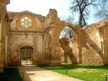 Restos de una iglesia en el que se aprecian las naves y los arcos en punta, con un rosetón sobre la puerta. No hay techos.