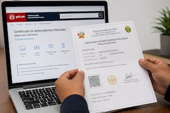 Manos sostienen un documento impreso frente a una computadora portátil que muestra el sitio de la Policía Nacional del Perú en gob.pe