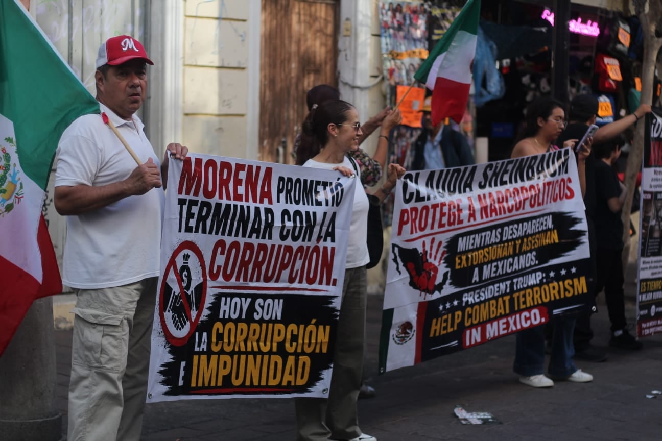 Manifestantes sostienen pancartas con mensajes políticos contra el partido Morena y la candidata Claudia Sheinbaum durante una protesta en Guadalajara, México. ((Zurisaddai González/ Infobae México))