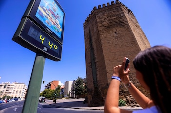 Una mujer fotografía un termómetro que marca 44 grados en Córdoba este viernes. (EFE/Salas)