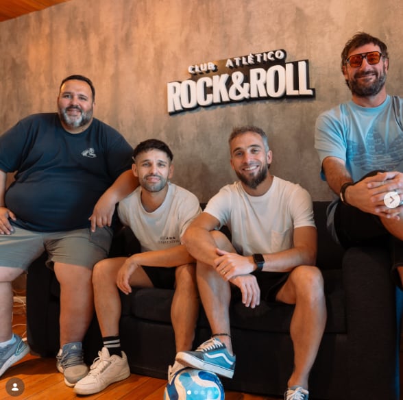 El futbolista Fernando Belluschi posa junto a los integrantes de la banda Cruzando el Charco en el set de su programa de streaming