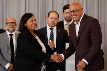 Dinorah Figuera, representante de la oposición venezolana, izquierda, y el presidente de la Asamblea Nacional, Jorge Rodríguez, se estrechan la mano tras firmar acuerdos al finalizar la segunda ronda de conversaciones políticas, el viernes 25 de septiembre de 2026, en Caracas, Venezuela. (AP Foto/Pedro Mattey)