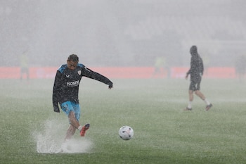 Los jugadores del Athletic Club calientan antes del partido de la sexta jornada de LaLiga que Levante UD y Athletic Club de Bilbao bajo la lluvia en el estadio Ciutat de Valencia, el miércoles por la noche. (EFE/Ana Escobar)