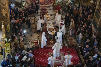 Sacerdotes ofician la ceremonia de despedida de Oleksiy Yukov —quien murió cuando exhumaba los cadáveres de soldados caídos en el frente de la región de Donetsk— en la catedral de San Vladimiro de Kiev, Ucrania, el sábado 8 de agosto de 2026. (Foto AP/Efrem Lukatsky)