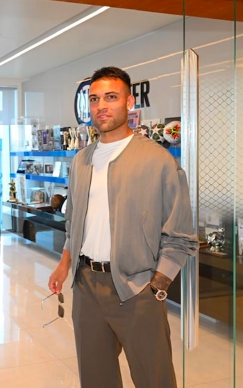 El delantero del Inter combina pantalón deportivo oscuro, remera blanca y chaqueta verde oliva, logrando un equilibrio entre funcionalidad y estilo