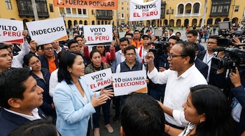 Keiko Fujimori y Roberto Sánchez interactúan con una multitud en una plaza. Personas sostienen carteles de 'INDECISOS' y 'VOTO POR EL PERÚ'. Hay cámaras de prensa.