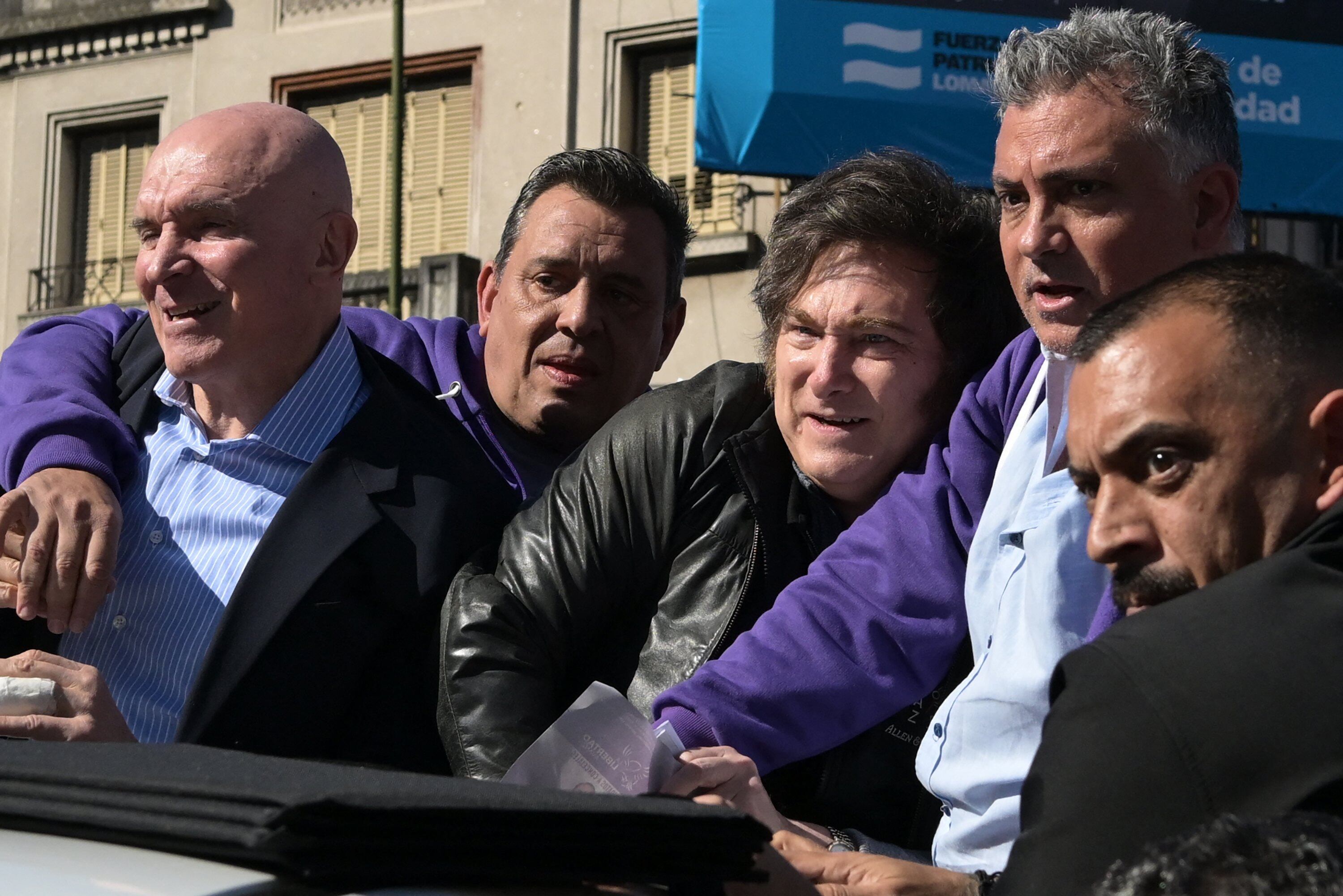 Espert, Milei y Parejas se resguardan de los ataques con piedras en Lomas de Zamora, junto a sus guardaespaldas que buscan protegerlo (Juan Mabromata/ AFP)
