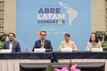 Dos hombres y dos mujeres sentados en una mesa, con un banner azul detrás que dice "Guatemala Abre Latam ConDatos 2026" y logotipos de organizaciones