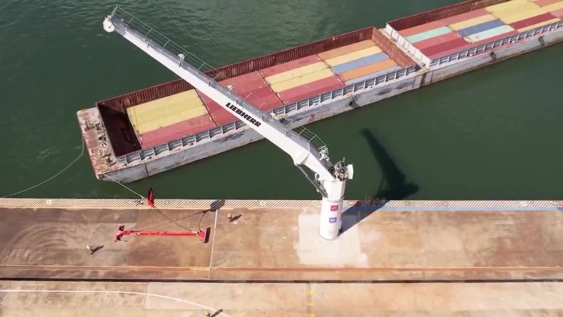 Una vista aérea muestra la moderna grúa de contenedores y una barcaza de carga operando en el recién privatizado puerto de Posadas, Misiones