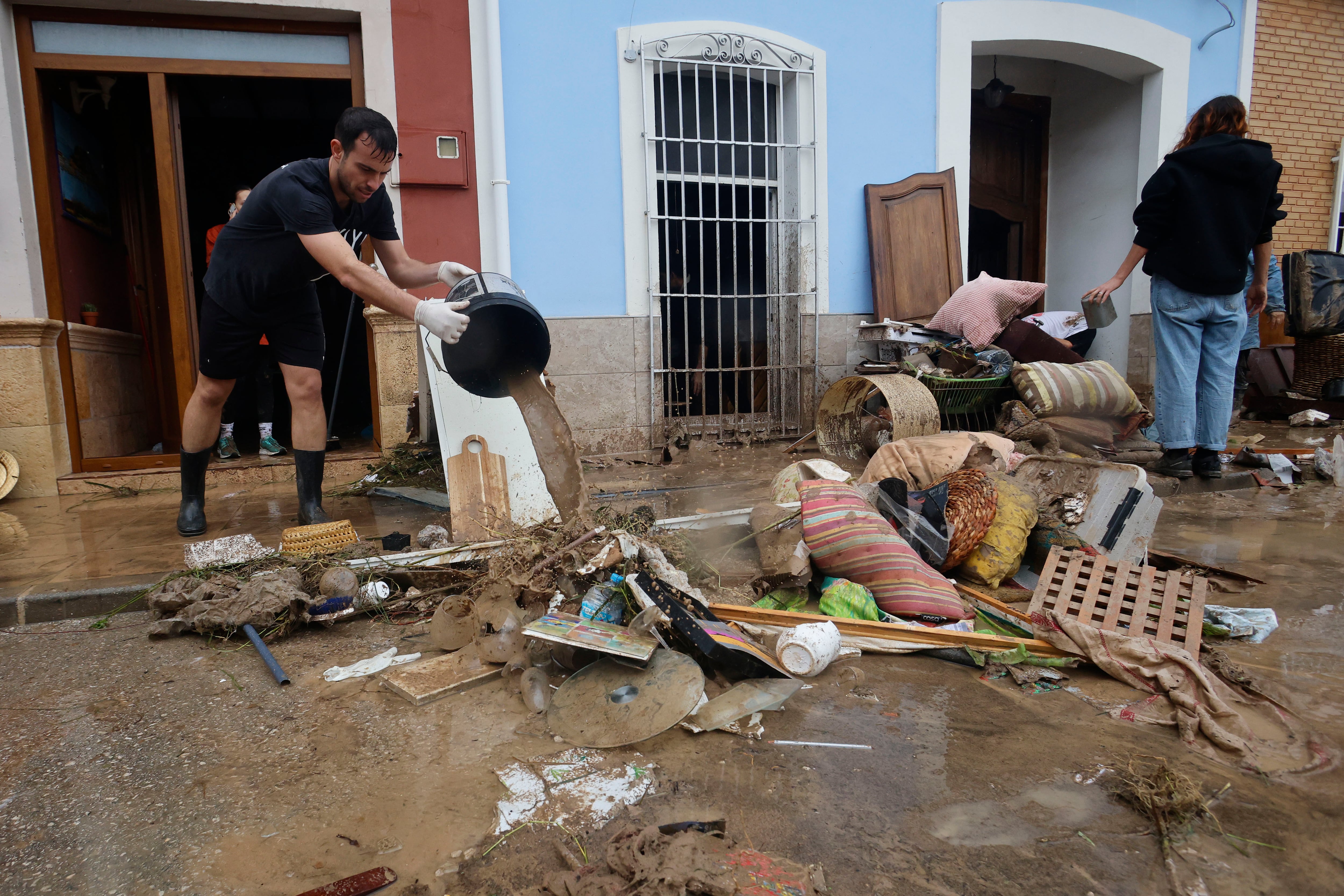 Vecinos de la localidad alicantina de Els Poblets achicando agua de sus casas tras la DANA Adam. (Morell/EFE)