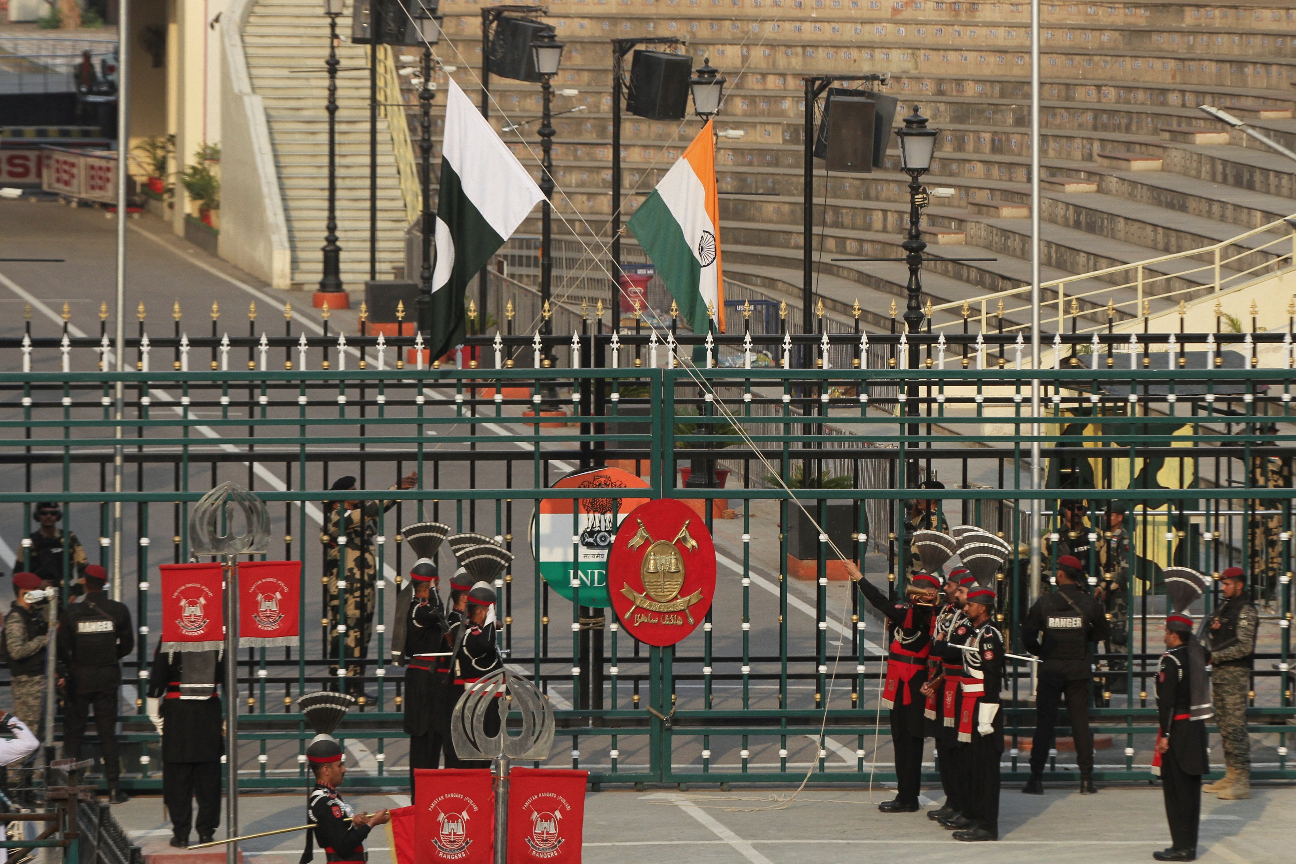 Soldados de los Rangers de Pakistán y de la Fuerza de Seguridad Fronteriza de la India arriaron sus banderas nacionales en el puesto de control conjunto de Pakistán y la India en la frontera de Wagah, cerca de Lahore (REUTERS/Mohsin Raza)