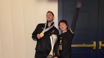 Santiago Giménez y Fer Serrano posan con una medalla de oro y un trofeo plateado.