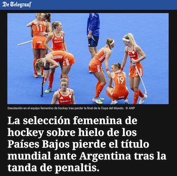 Jugadoras de hockey sobre césped vestidas con uniforme naranja se encuentran en la cancha azul junto al titular del periódico De Telegraaf