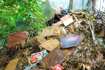 Restos de muebles, ramas y desechos voluminosos acumulados a la orilla de una quebrada en San Salvador Centro, evidencia del impacto de la disposición inadecuada de residuos en zonas vulnerables (Foto cortesía Desechos Sólidos San Salvador).