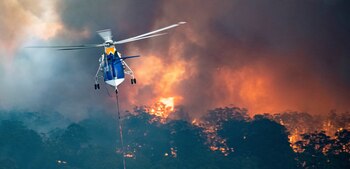 En esta imagen, tomada el 30 de diciembre de 2019 y proporcionada por el gobierno del estado de Victoria, un helicóptero participa en las labores de extinción de un incendio en East Gippsland, Victoria, Australia (Gobierno estatal de Victoria vía AP)