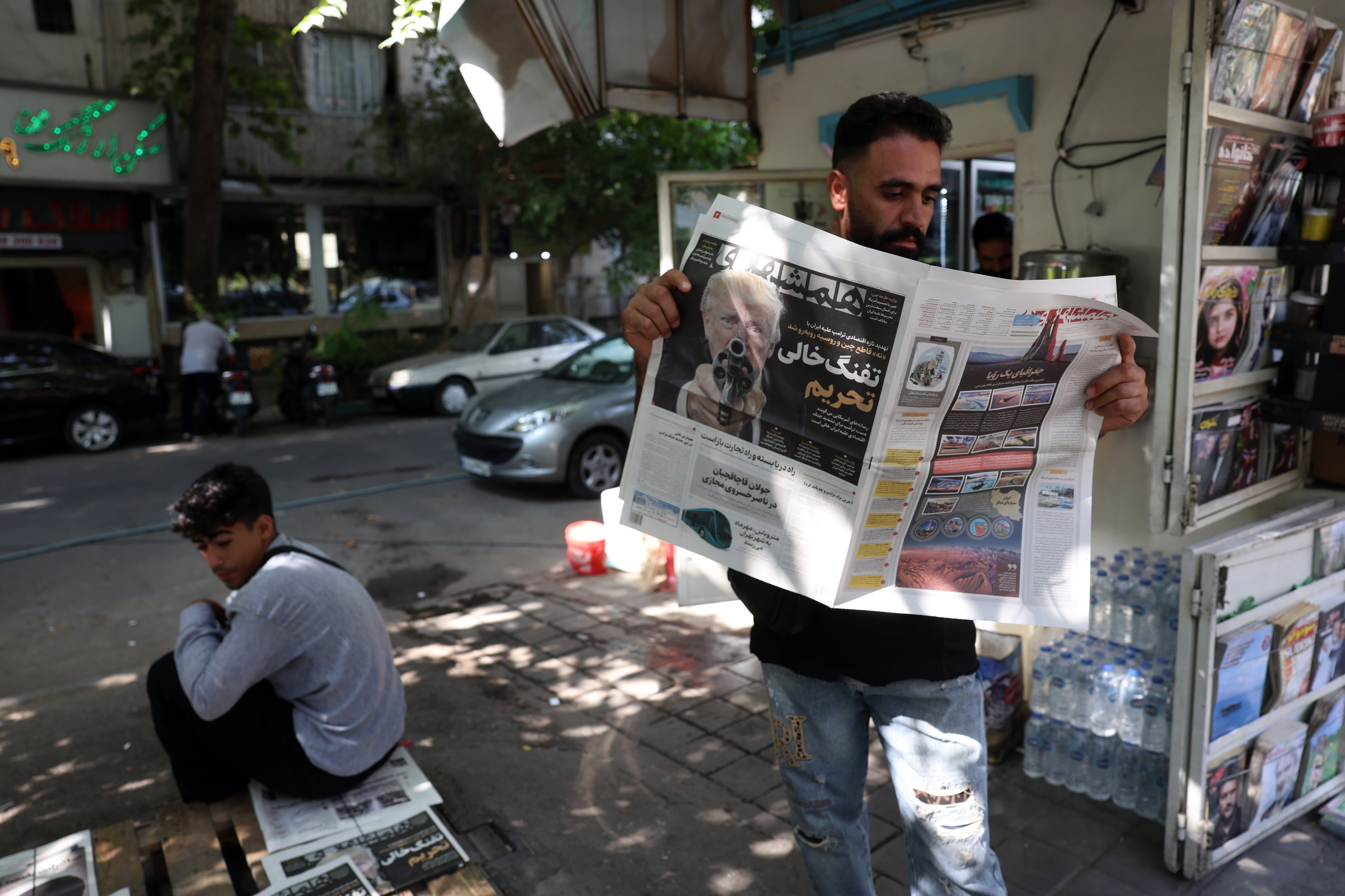Un hombre lee un diario en una calle de Teherán (EFE/EPA/ABEDIN TAHERKENAREH)