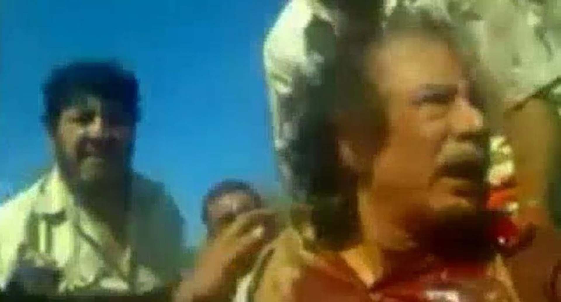 Muamar Gadafi momentos antes de ser linchado y ajusticiado. Un bombardeo de la OTAN desarticuló la caravana de vehículos en la que el líder libio intentó romper el cerco rebelde en Sirte