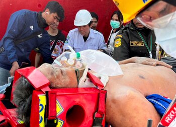 An injured person receives medical attention near the site of a collapsed building after a strong earthquake struck central Myanmar on Friday, earthquake monitoring services said, which affected Bangkok as well with hundreds of people pouring out of buildings in the Thai capital in panic after the tremors, in Bangkok, Thailand, March 28, 2025. REUTERS/Ann Wang