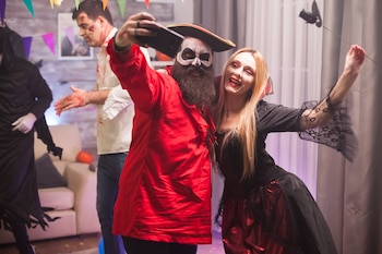 Una mujer disfraza de vampira y un hombre de pirata en una fiesta de Halloween (Magnific)
