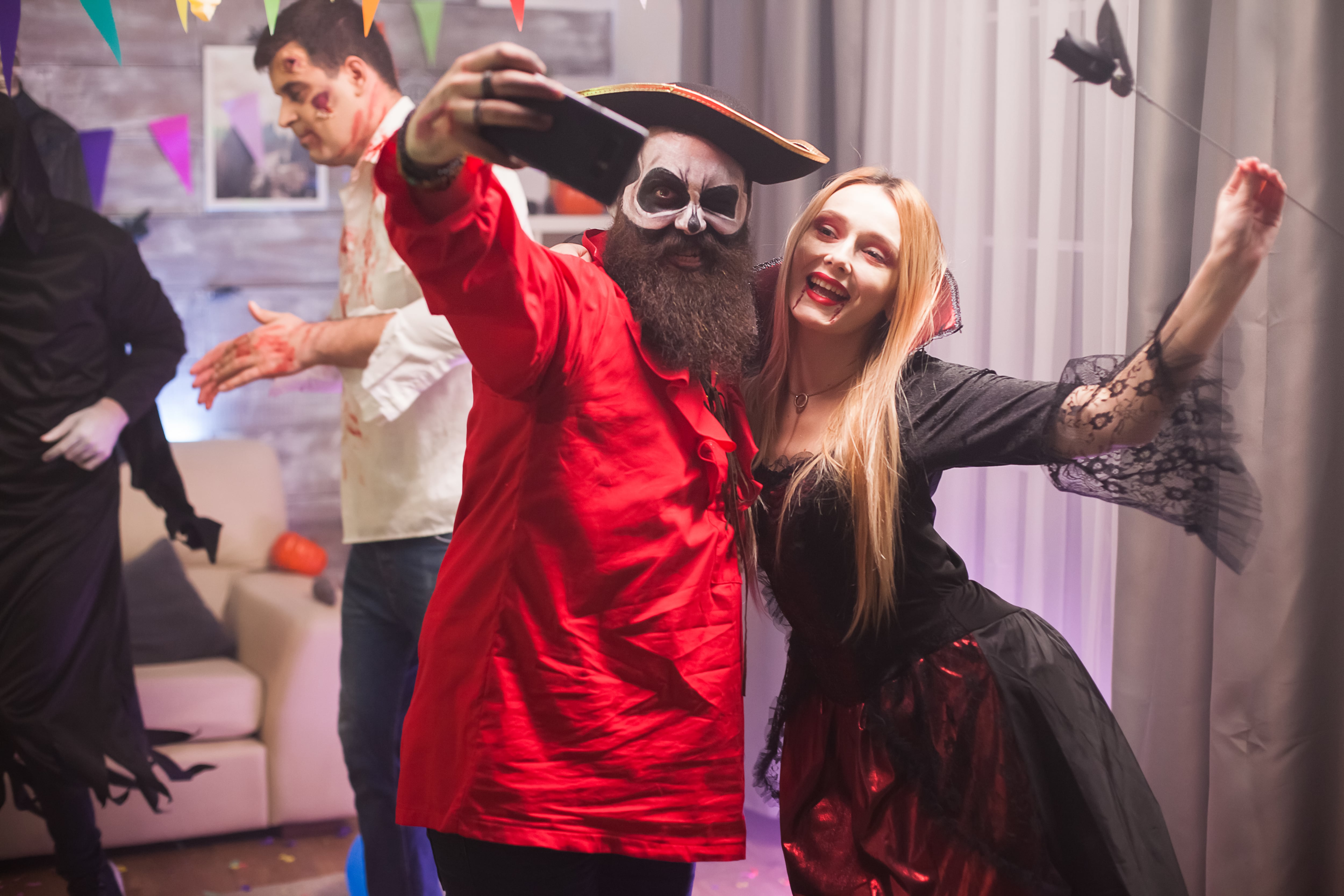 Una mujer disfraza de vampira y un hombre de pirata en una fiesta de Halloween (Magnific)
