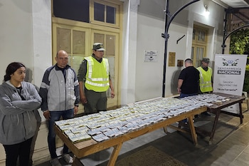 Interior desarmado del tablero de un vehículo con numerosos fajos de billetes atados con bandas elásticas y cableado a la vista