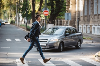 Un hombre cruzando por un paso de peatones