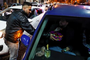 Palestinos distribuyen dulces mientras celebran el atentado contra israelíes, 27 de enero de 2023. REUTERS/Mussa Qawasma