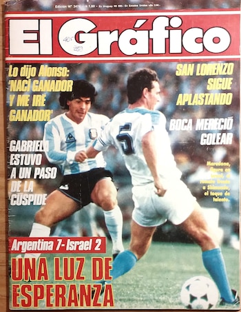 Portada de la revista El Gráfico con título rojo y blanco, mostrando a dos futbolistas argentinos con camisetas celestes y blancas en la cancha