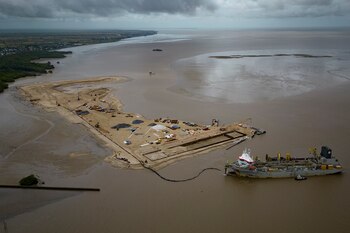 Un barco crea una isla artificial extrayendo arena de la playa para la creación de un puerto costero para la producción de petróleo en la desembocadura del Río Demerara, en Georgetown, Guyana, el miércoles 12 de abril de 2023. (AP Foto/Matias Delacroix)