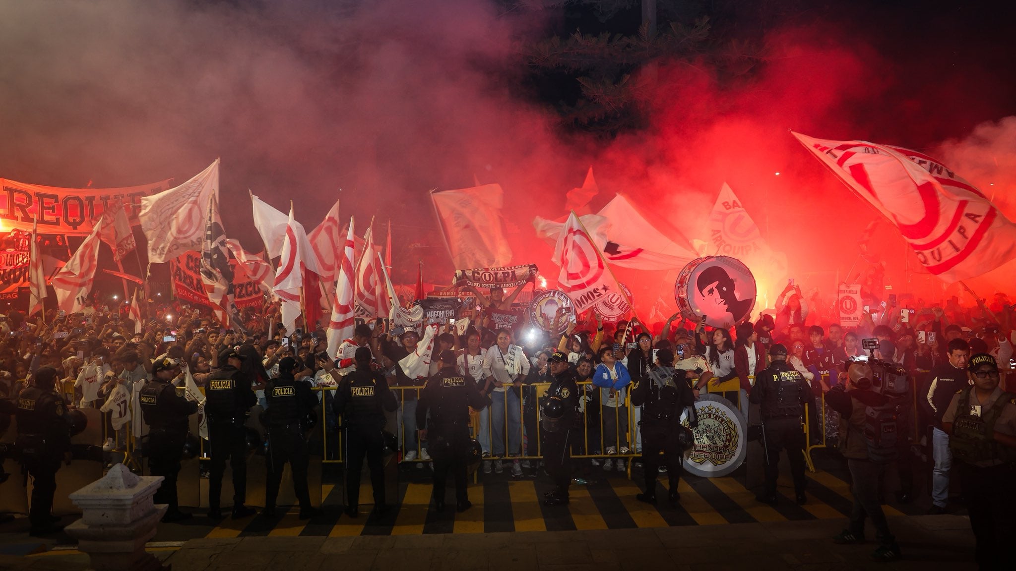 Centenas de torcedores do Universitario participam de um grande hasteamento de bandeira em Arequipa, iluminando a noite com fogos e bandeiras vermelhas, antes da partida contra o Melgar pela Liga 1. (@Universitario)