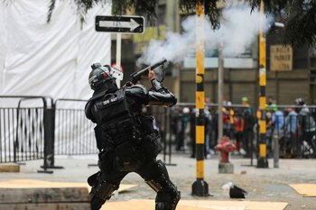 Foto de archivo. Un miembro del Escuadrón Móvil Antidisturbios (ESMAD) de la Policía Nacional dispara una gas lagrimógeno para dispersar a un grupo de manifestantes en Bogotá, Colombia, 28 de abril, 2021. REUTERS/Luisa González