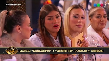 Luana Fernández, con cabello castaño y camisa clara, sentada en una mesa junto a otras tres mujeres, con un gráfico de televisión en la parte inferior