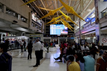 Varias personas esperan abordar sus vuelos en el aeropuerto internacional de Maiquetía, en Caracas (EFE/ Miguel Gutierrez)