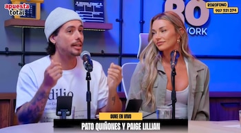 Un hombre con gorro de lana blanco gesticula frente a un micrófono junto a una mujer en un estudio de grabación