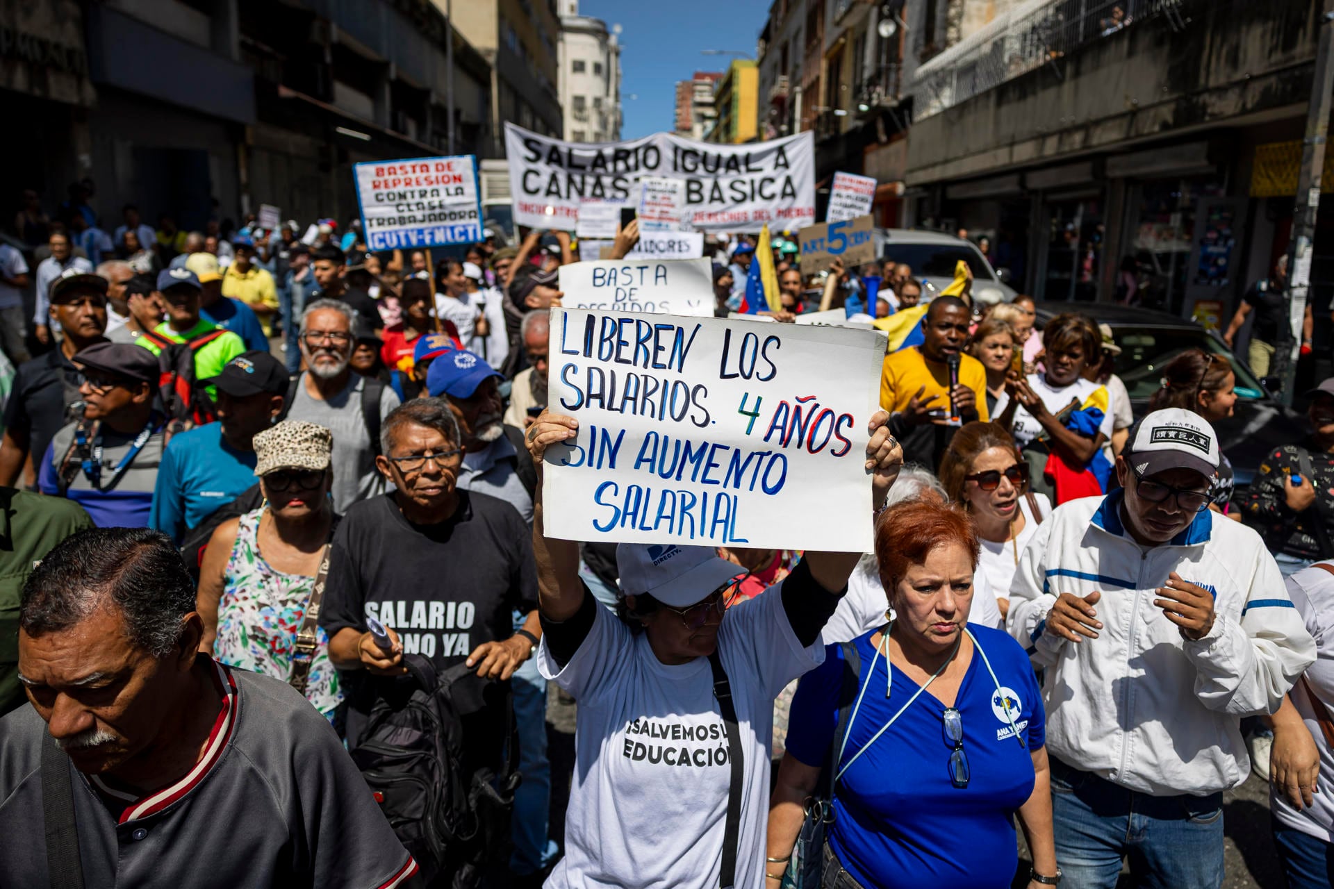 Trabajadores venezolanos marcharon por salarios dignos y justos, mostrando carteles que denuncian cuatro años sin aumento salarial en el país.