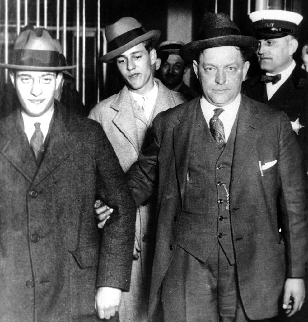 Nathan Leopold (izquierda) y Richard Loeb entran en la cárcel del condado de Cook, en Chicago, junto al ayudante del sheriff David Eefeldt (centro, derecha) y el ayudante del alcaide Hans Thompson (derecha), tras ser detenidos en relación con el asesinato de Bobby Franks, de 14 años, el 29 de mayo de 1924 (AP Photo)