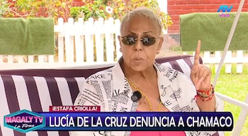 Lucía de la Cruz con gafas oscuras y camisa estampada levanta un dedo mientras declara en una transmisión de televisión