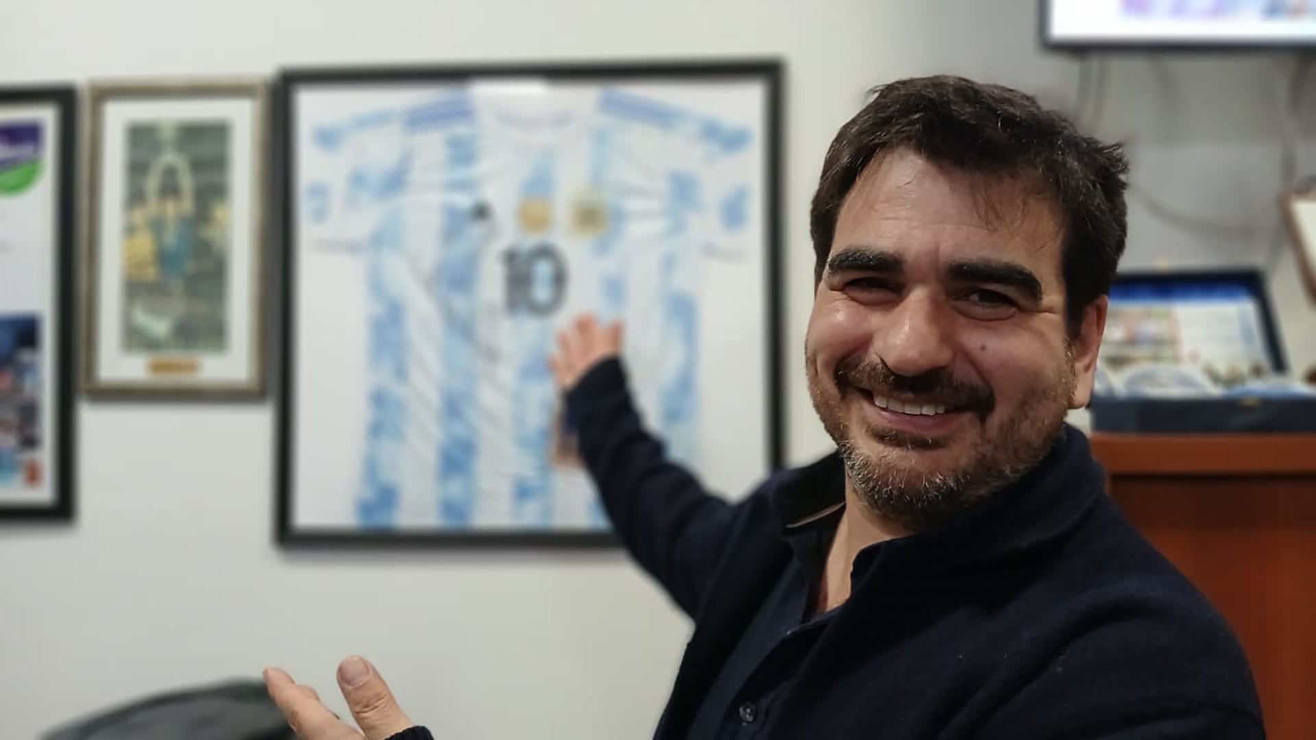 Acuña en la previa de la presentación en la oficina del presidente comunal, con camisetas y recuerdos de Scaloni.