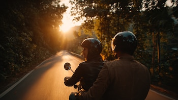 Dos personas en motocicleta usando casco, viaje seguro y responsable. - (Imagen Ilustrativa Infobae)