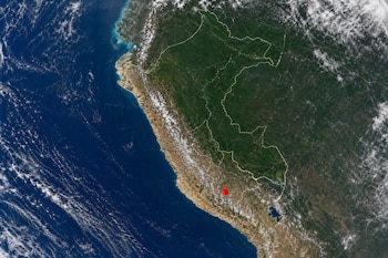 Fotografía satelital del territorio de Perú con divisiones políticas blancas y un punto rojo en la zona sur.