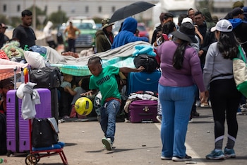 Migrantes esperan para cruzar a Perú en el paso fronterizo de Chacalluta en Arica, Chile, el viernes 28 de noviembre de 2025. (AP Foto/Ibar Silva)