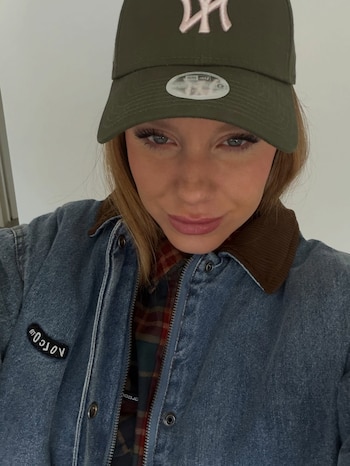 Primer plano de Rocío Pardo con una gorra de béisbol verde y una chaqueta de mezclilla azul