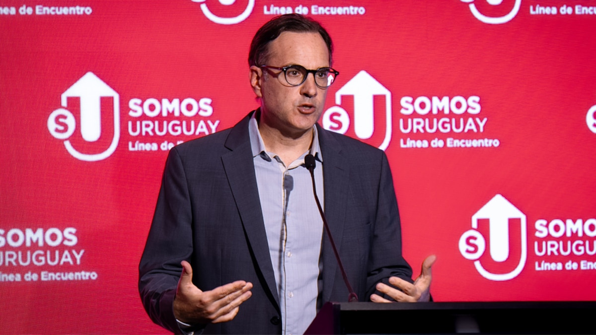 Billetes en dólares y pesos uruguayos sobre un escritorio