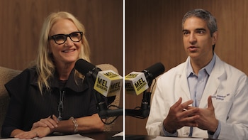 Mel Robbins a la izquierda y un médico con bata blanca a la derecha, sentados en un estudio frente a micrófonos de pódcast