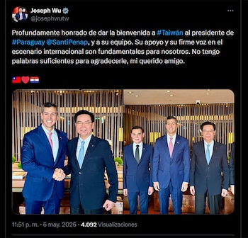 Santiago Peña y Joseph Wu se dan la mano sonriendo, vestidos con traje y corbata, junto a otros tres hombres en un interior moderno con fondo de listones de madera