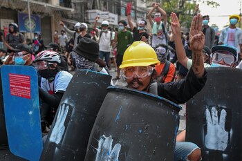 Manifestantes sostienen escudos durante una