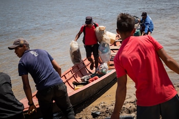 Mineros provenientes de la mina derrumbada Bulla Loca desembarcan en La Paragua, estado Bolívar (Venezuela). EFE/ Rayner Peña R.