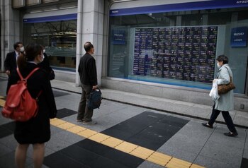FOTO DE A RCHIVO: Varias personas con mascarillas observan una pantalla con datos de cotización bursátil en Tokio, Japón, el 10 de marzo de 2020. REUTERS/Stoyan Nenov